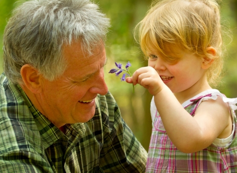 Grandfather and granddaughter looking at leaf
