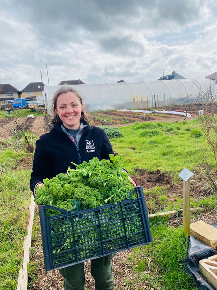 Rosa Beesley carrying a crate of vegetables